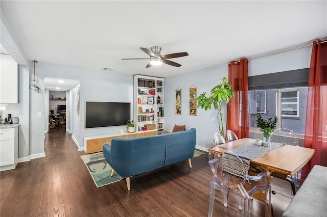 living area with baseboards, ceiling fan, visible vents, and dark wood-type flooring