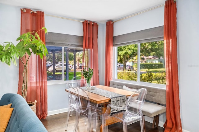 dining room with baseboards, a wealth of natural light, and wood finished floors