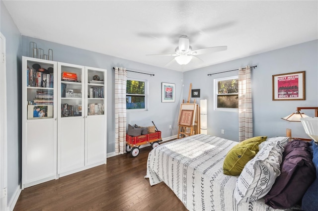 bedroom featuring a ceiling fan, baseboards, and dark wood-style floors