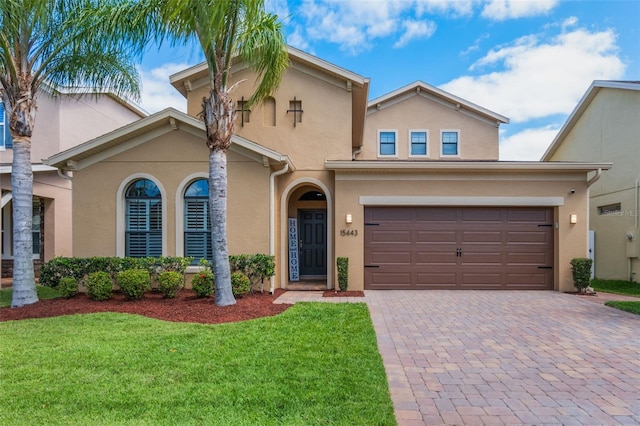 15443 Sugarcup Ct, Orlando, FL 32828 - mediterranean / spanish-style house with stucco siding, decorative driveway, a front yard, and a garage