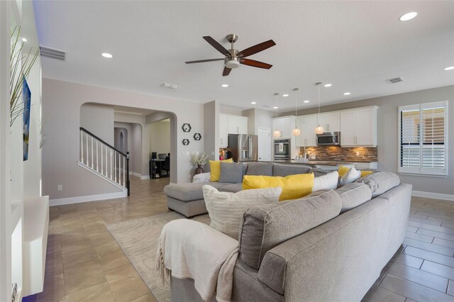 15443 Sugarcup Ct, Orlando, FL 32828 - living area with arched walkways, a ceiling fan, recessed lighting, baseboards, and stairway