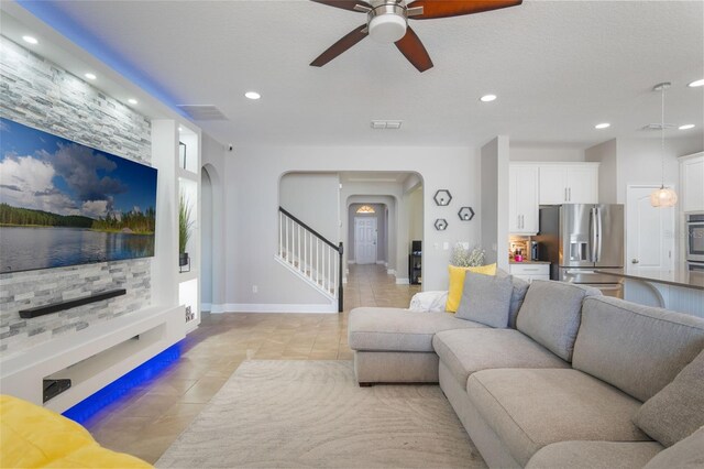 15443 Sugarcup Ct, Orlando, FL 32828 - living area featuring arched walkways, light tile patterned floors, stairway, a ceiling fan, and recessed lighting