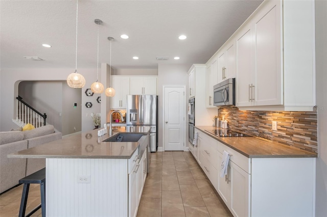 15443 Sugarcup Ct, Orlando, FL 32828 - kitchen featuring stainless steel appliances, open floor plan, a breakfast bar area, backsplash, and recessed lighting