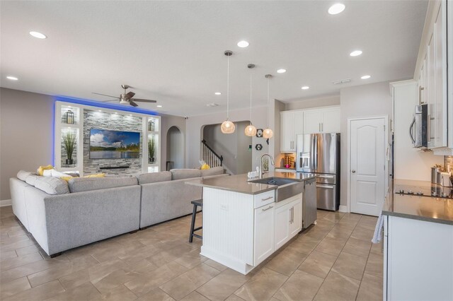 15443 Sugarcup Ct, Orlando, FL 32828 - kitchen with appliances with stainless steel finishes, arched walkways, open floor plan, a sink, and recessed lighting