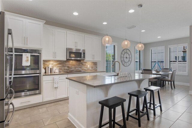 15443 Sugarcup Ct, Orlando, FL 32828 - kitchen featuring stainless steel appliances, a sink, backsplash, light tile patterned flooring, and recessed lighting
