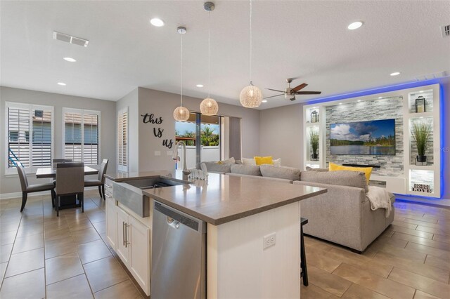 15443 Sugarcup Ct, Orlando, FL 32828 - kitchen with dishwasher, ceiling fan, a center island with sink, recessed lighting, and white cabinetry