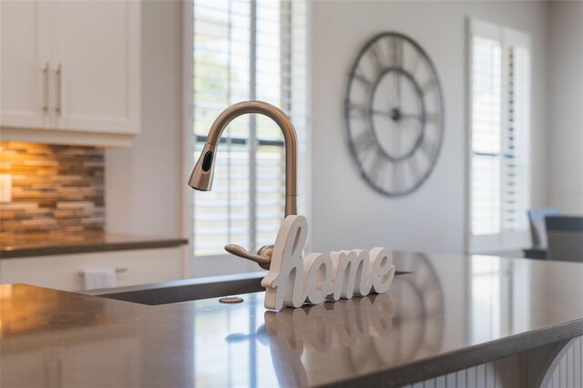 15443 Sugarcup Ct, Orlando, FL 32828 - kitchen view of tasteful backsplash, white cabinets, and dark countertops