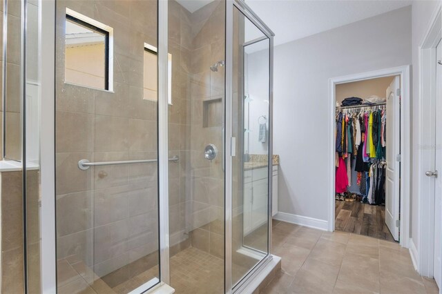 15443 Sugarcup Ct, Orlando, FL 32828 - full bath with a shower stall, baseboards, a spacious closet, and tile patterned floors