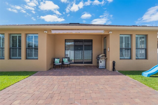 15443 Sugarcup Ct, Orlando, FL 32828 - rear view of property featuring stucco siding and a patio