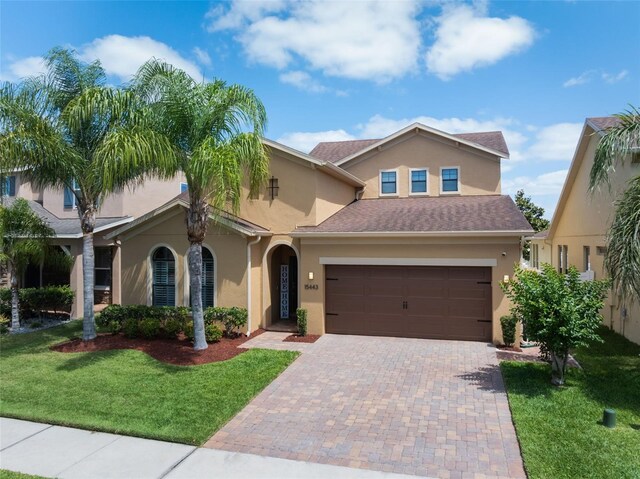 15443 Sugarcup Ct, Orlando, FL 32828 - view of front facade with stucco siding, a front yard, and decorative driveway