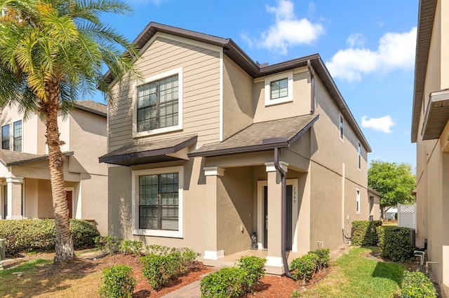 view of front of home featuring stucco siding and a shingled roof