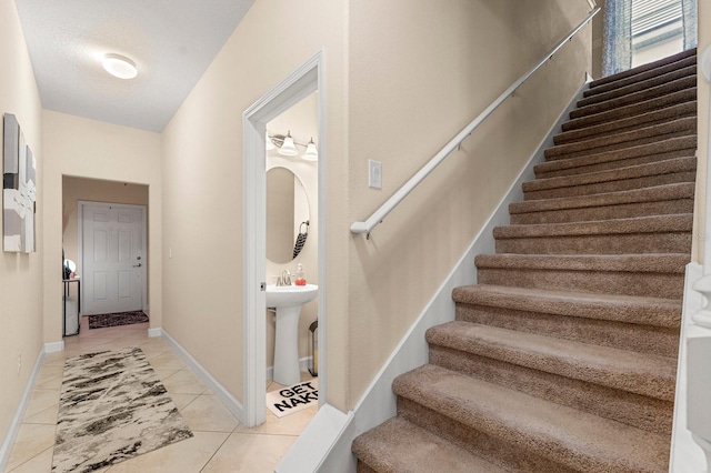 stairs featuring tile patterned flooring and baseboards
