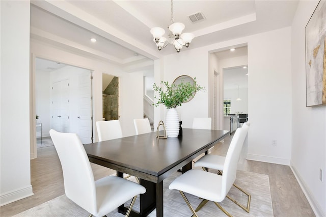 10139 Austrina Oak Loop, Winter Garden, FL 34787 - dining area with a tray ceiling, a chandelier, baseboards, and light wood-style floors
