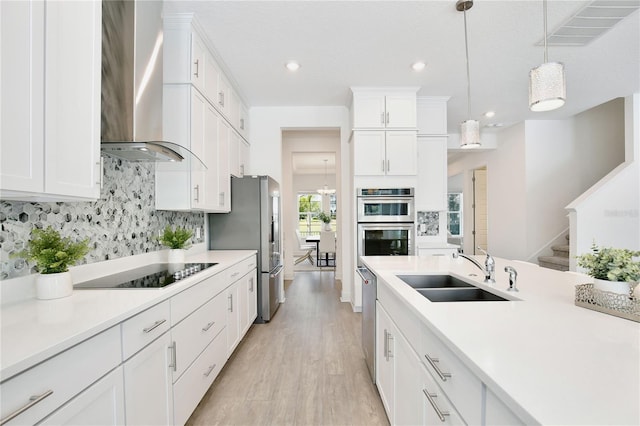 10139 Austrina Oak Loop, Winter Garden, FL 34787 - kitchen with appliances with stainless steel finishes, a sink, light wood finished floors, wall chimney exhaust hood, and visible vents