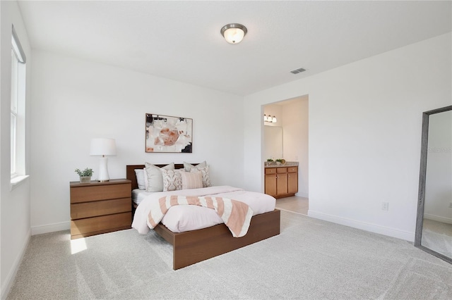10139 Austrina Oak Loop, Winter Garden, FL 34787 - bedroom featuring baseboards, light colored carpet, ensuite bathroom, and visible vents