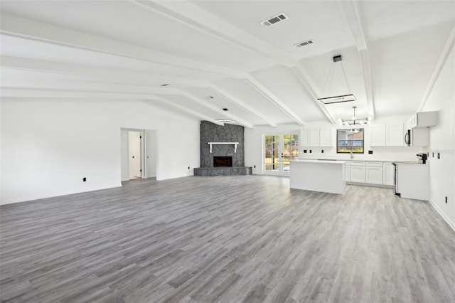 4510 Bonanza St, Cocoa, FL 32927 - unfurnished living room featuring lofted ceiling with beams, light wood-style flooring, and visible vents