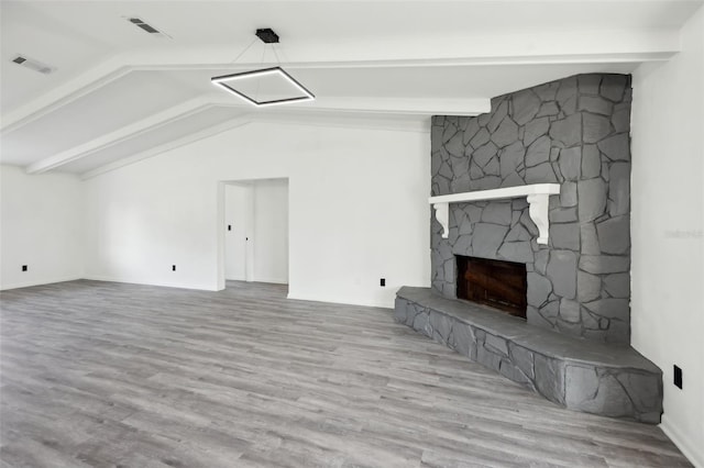 4510 Bonanza St, Cocoa, FL 32927 - unfurnished living room featuring vaulted ceiling with beams, visible vents, a stone fireplace, and wood finished floors