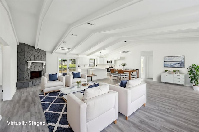 4510 Bonanza St, Cocoa, FL 32927 - living room featuring lofted ceiling with beams, a stone fireplace, light wood-style flooring, and visible vents