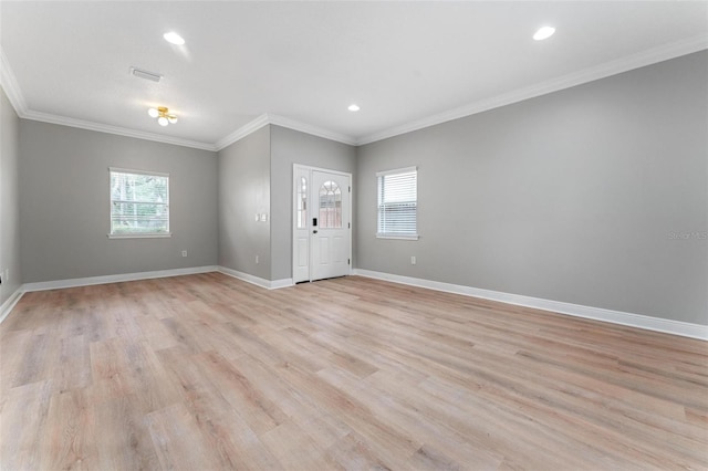 interior space featuring baseboards, ornamental molding, light wood-style flooring, and a healthy amount of sunlight
