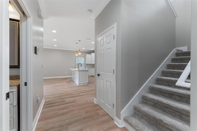 stairway featuring recessed lighting, baseboards, ornamental molding, and wood finished floors