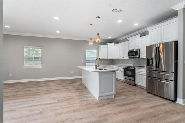 kitchen featuring a sink, ornamental molding, stainless steel appliances, and a wealth of natural light
