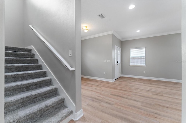 staircase with visible vents, wood finished floors, baseboards, ornamental molding, and recessed lighting