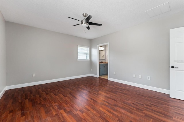 unfurnished room with a ceiling fan, baseboards, dark wood-style floors, and a sink