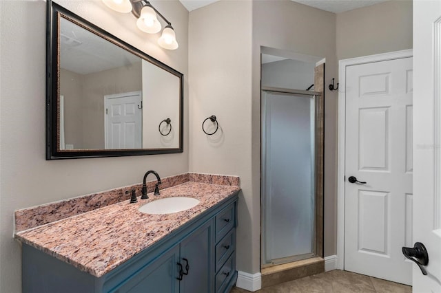 bathroom with vanity, a shower stall, and tile patterned floors