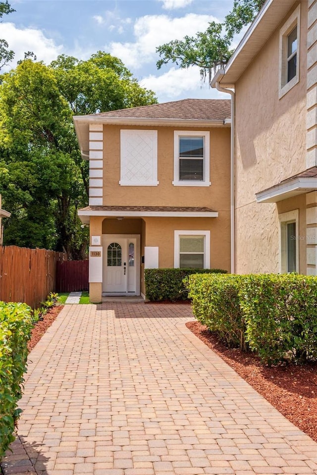 townhome / multi-family property with fence and stucco siding