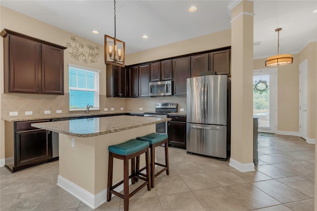kitchen with appliances with stainless steel finishes, dark brown cabinetry, a healthy amount of sunlight, and tasteful backsplash