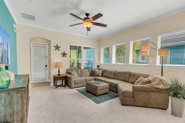 living area featuring crown molding, arched walkways, carpet, a ceiling fan, and visible vents