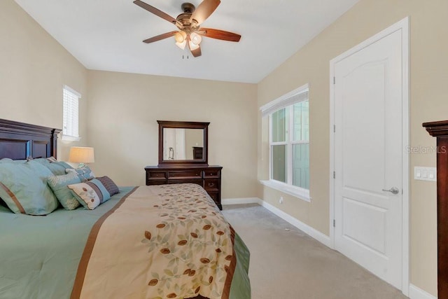 bedroom featuring light colored carpet, baseboards, and ceiling fan