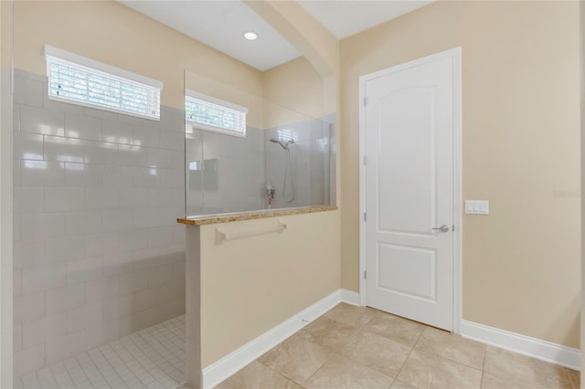 full bathroom with a walk in shower, baseboards, and tile patterned flooring