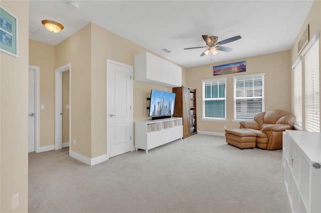 living area featuring a ceiling fan, baseboards, light colored carpet, and visible vents