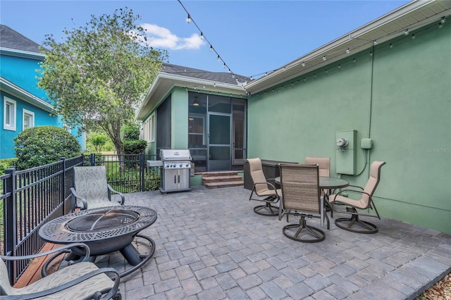 view of patio featuring fence, an outdoor fire pit, a sunroom, entry steps, and a grill
