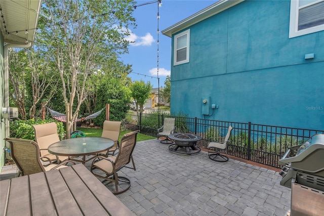 view of patio featuring an outdoor fire pit, fence, grilling area, and outdoor dining space