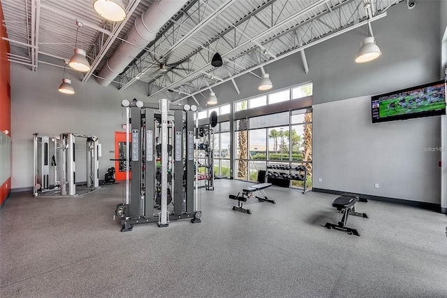 gym with baseboards and a high ceiling
