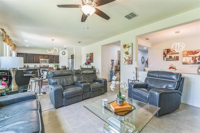 2815 Shelburne Way, Saint Cloud, FL 34772 - living area featuring visible vents, ceiling fan with notable chandelier, and light tile patterned floors