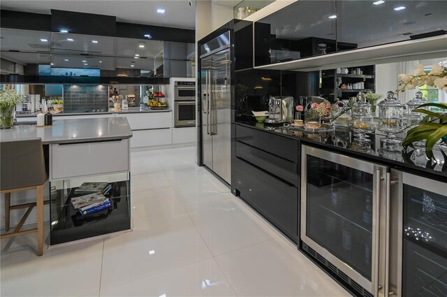 bar area featuring stainless steel appliances, wine cooler, and light tile patterned floors