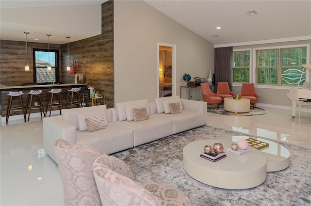 tiled living room featuring plenty of natural light, bar, vaulted ceiling, wood walls, and recessed lighting