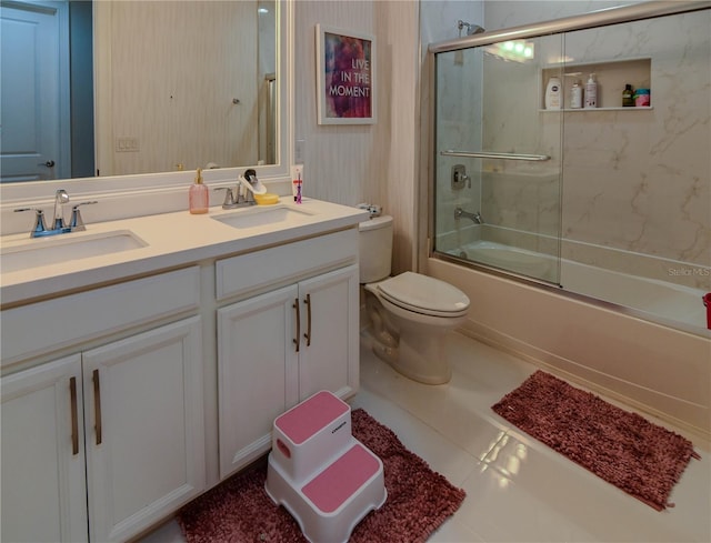full bathroom with double vanity, combined bath / shower with glass door, and toilet