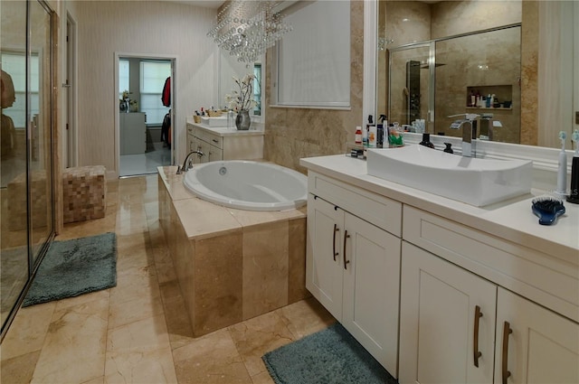 full bath with a shower stall, a bath, vanity, and a chandelier