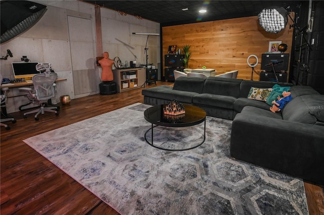 living room with an office area, wood finished floors, and wooden walls