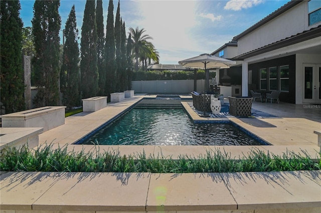 view of pool featuring a patio area and an in-ground hot tub