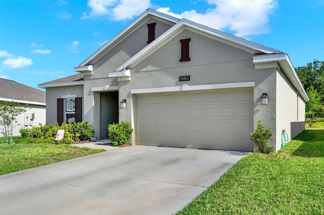 view of front of home featuring a garage, driveway, a front yard, and stucco siding