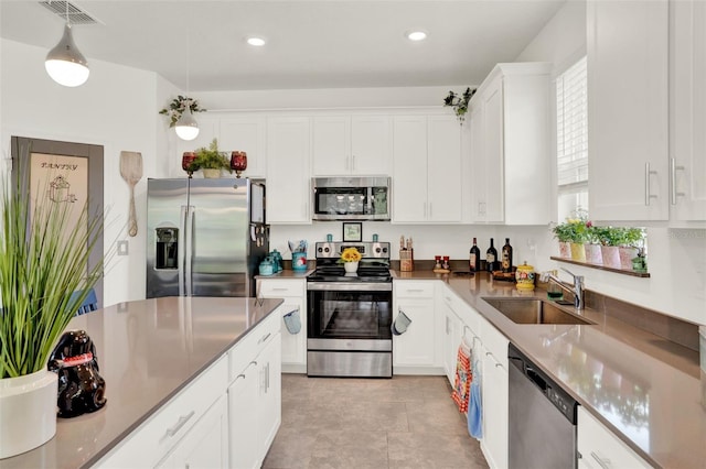 kitchen with visible vents, recessed lighting, white cabinetry, a sink, and stainless steel appliances