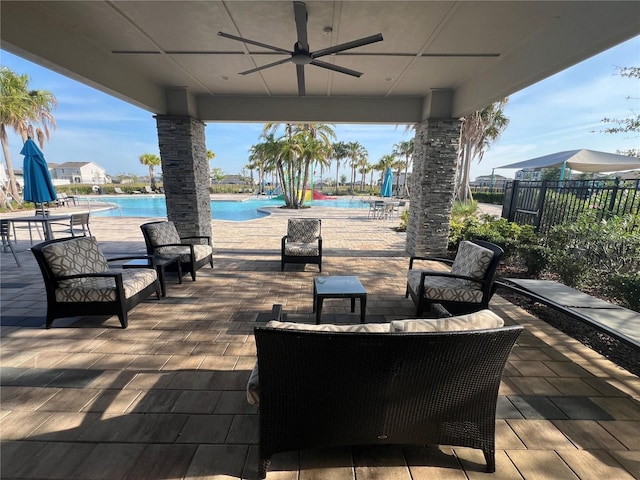 view of patio with ceiling fan, outdoor lounge area, fence, and a community pool