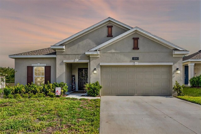 ranch-style house with concrete driveway, an attached garage, and stucco siding
