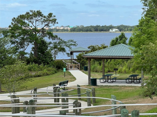 view of property's community with a lawn, a water view, and a gazebo