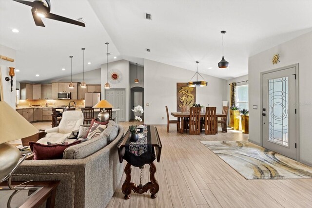 living room with light wood-type flooring, recessed lighting, ceiling fan, and lofted ceiling